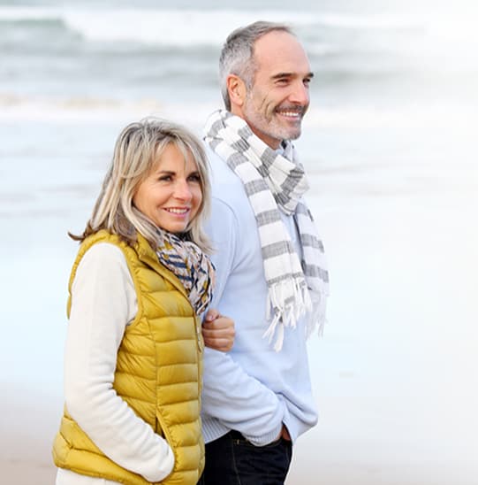Older couple walking on the beach